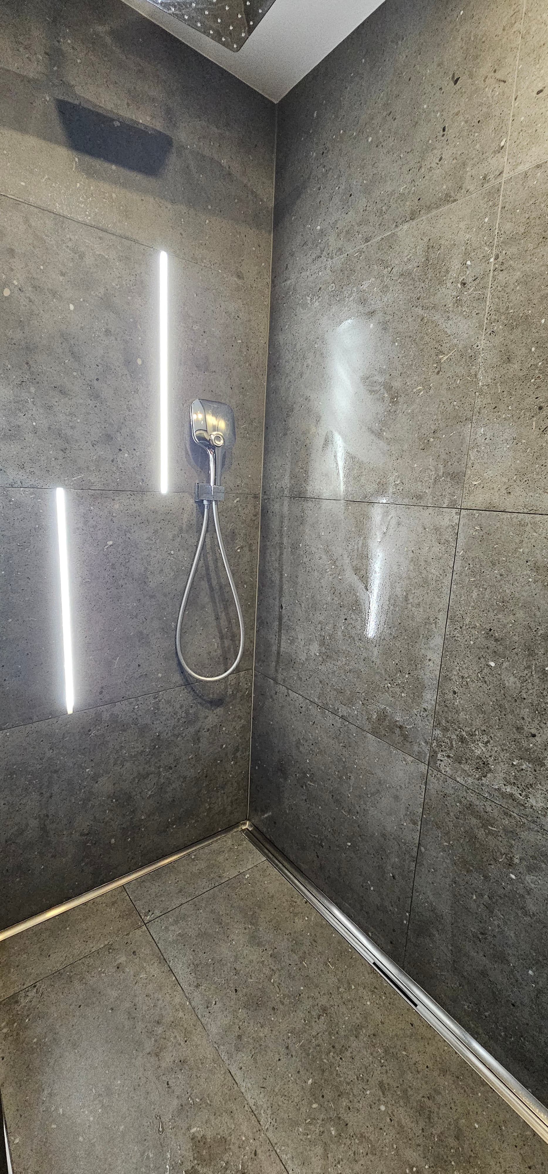 Bodenebene Dusche mit vertikalen LED-Lichtlinien in Fliesen-Betonoptik – Fliesenleger Ingelheim